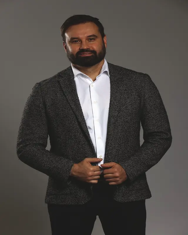 Steve van Diest in a grey blazer against a grey studio backdrop