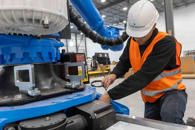A technician works on a robotic arm in the Promise Robotics factory